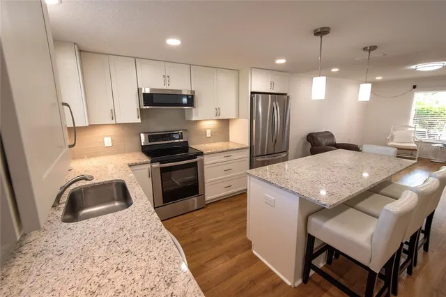 a bathroom with a granite countertop sink a toilet and shower
