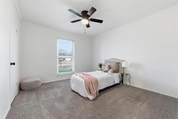 a spacious bedroom with a bed and a ceiling fan