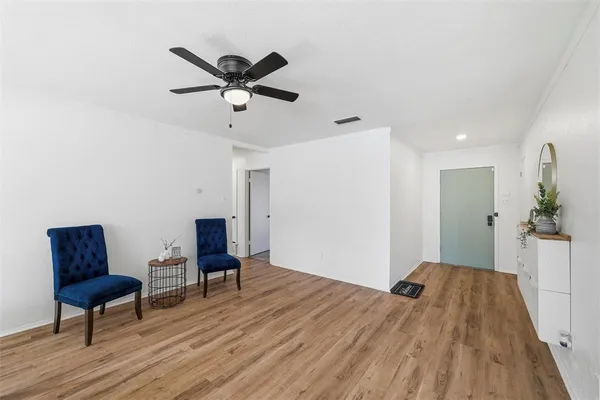a view of room with wooden floor a ceiling fan and a window