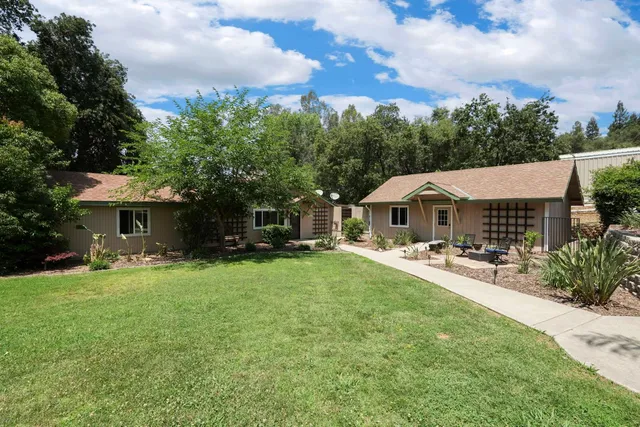 a view of a backyard with wooden fence and a tree
