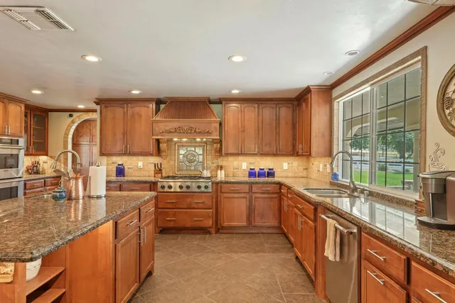 a kitchen with a sink a window and stainless steel appliances