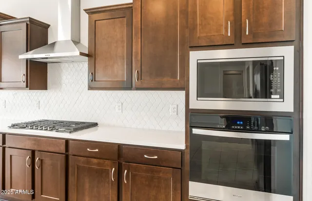 a kitchen with kitchen island granite countertop a sink and a stove top oven with wooden floor