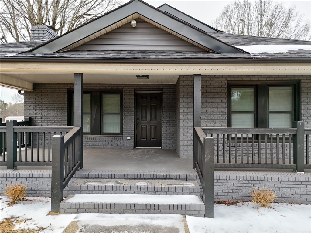 This charming residence features a classic brick exterior and an inviting covered porch.