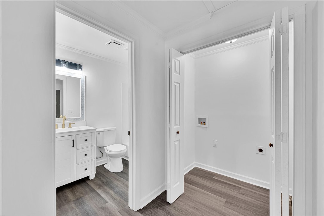 801 Cherokee Road Pelzer, SC 29669 - Photo 23 of 45 This interior image showcases a crisp, clean bathroom with modern finishes and a nearby laundry space.