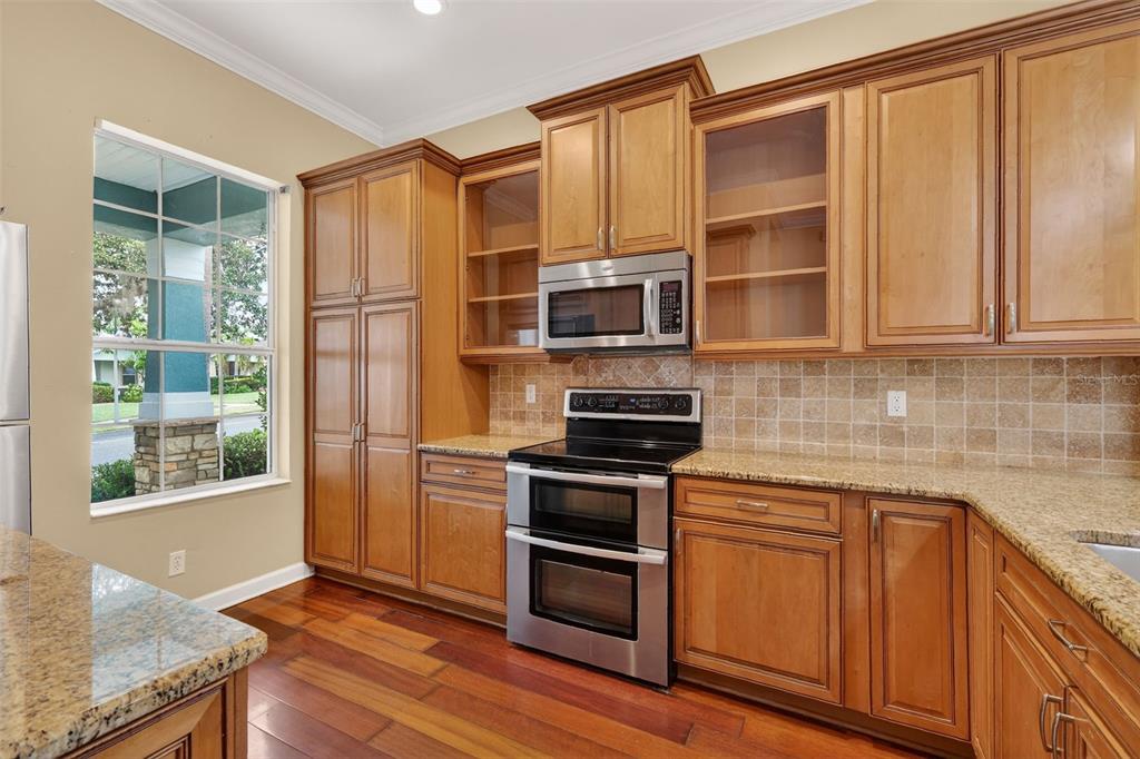 2117 Appalachee Circle Tavares, FL 32778 - Photo 6 of 30 a kitchen with stainless steel appliances granite countertop a refrigerator and wooden cabinets