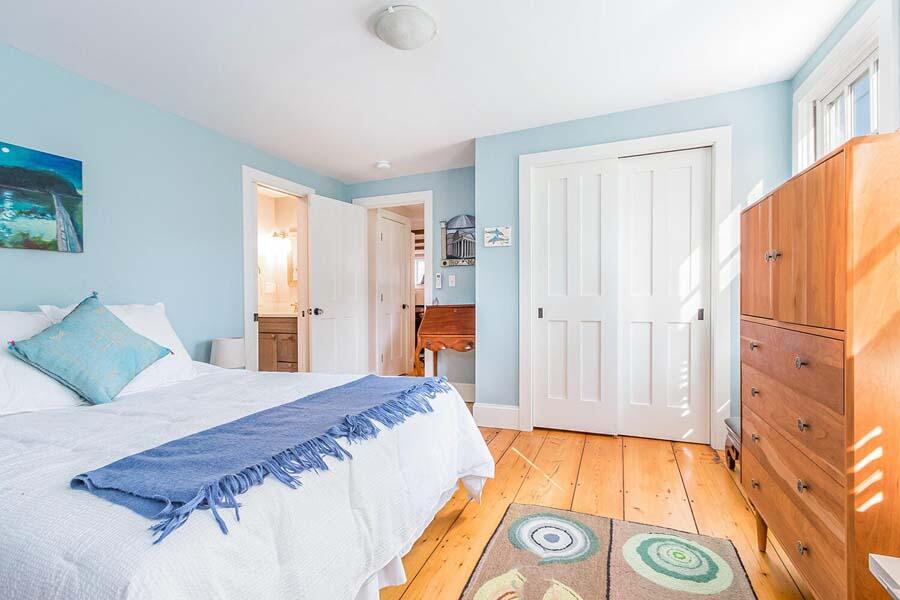 180 Commercial Street Wellfleet, MA 02667 - Photo 14 of 41 a bedroom with a bed and a lamp on dresser