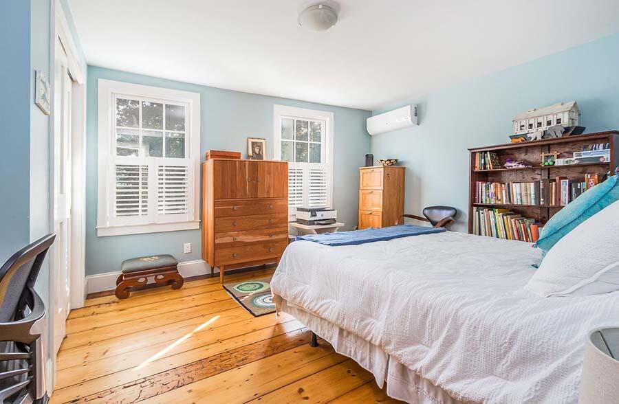 180 Commercial Street Wellfleet, MA 02667 - Photo 15 of 41 a bedroom with a bed a large window and a book shelf