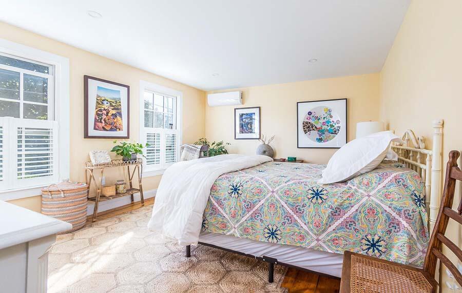180 Commercial Street Wellfleet, MA 02667 - Photo 18 of 41 a spacious bedroom with a bed a painting on the wall and a window