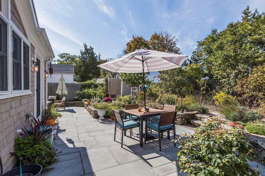 180 Commercial Street Wellfleet, MA 02667 - Photo 36 of 41 a view of a patio with table and chairs under an umbrella