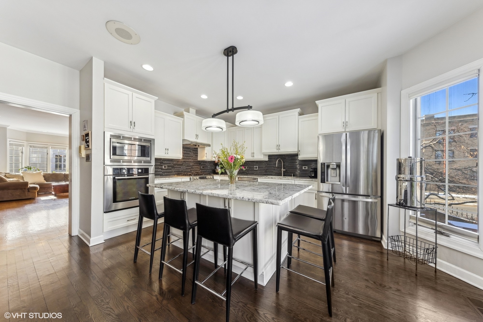 731 South Racine Avenue, Unit B Chicago, IL 60607 - Photo 7 of 29 a kitchen with stainless steel appliances kitchen island granite countertop a refrigerator a stove a dining table and chairs with wooden floor