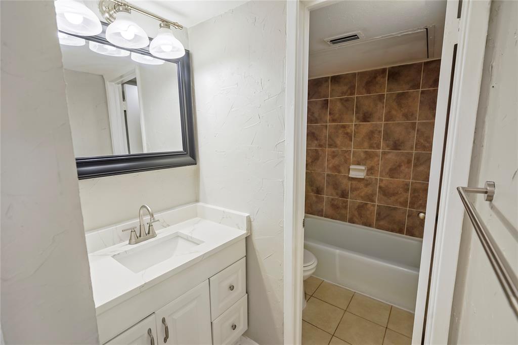 4523 North O'Connor Road, Unit 1177 Irving, TX 75062 - Photo 26 of 31 a bathroom with a sink a toilet a mirror and shower