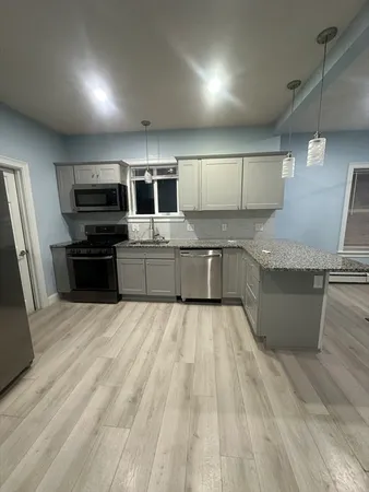 a large kitchen with stainless steel appliances kitchen island granite countertop a large counter top and oven