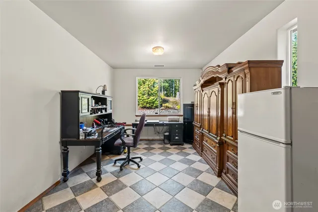 a view of a workspace with furniture and a window