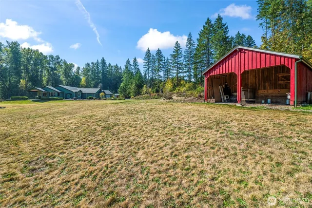 a view of a house with backyard and trees