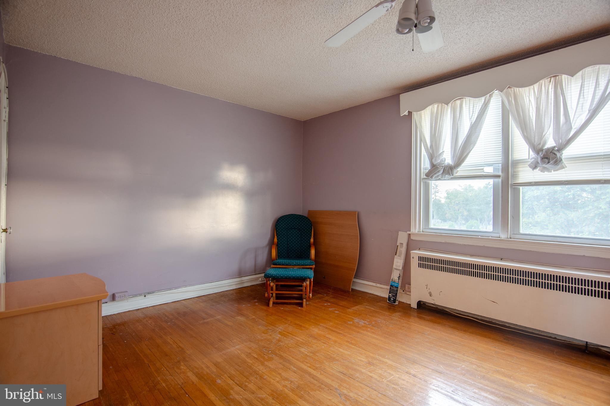 7617 Woolston Avenue Philadelphia, PA 19150 - Photo 17 of 24 a bedroom with a chair and a large window