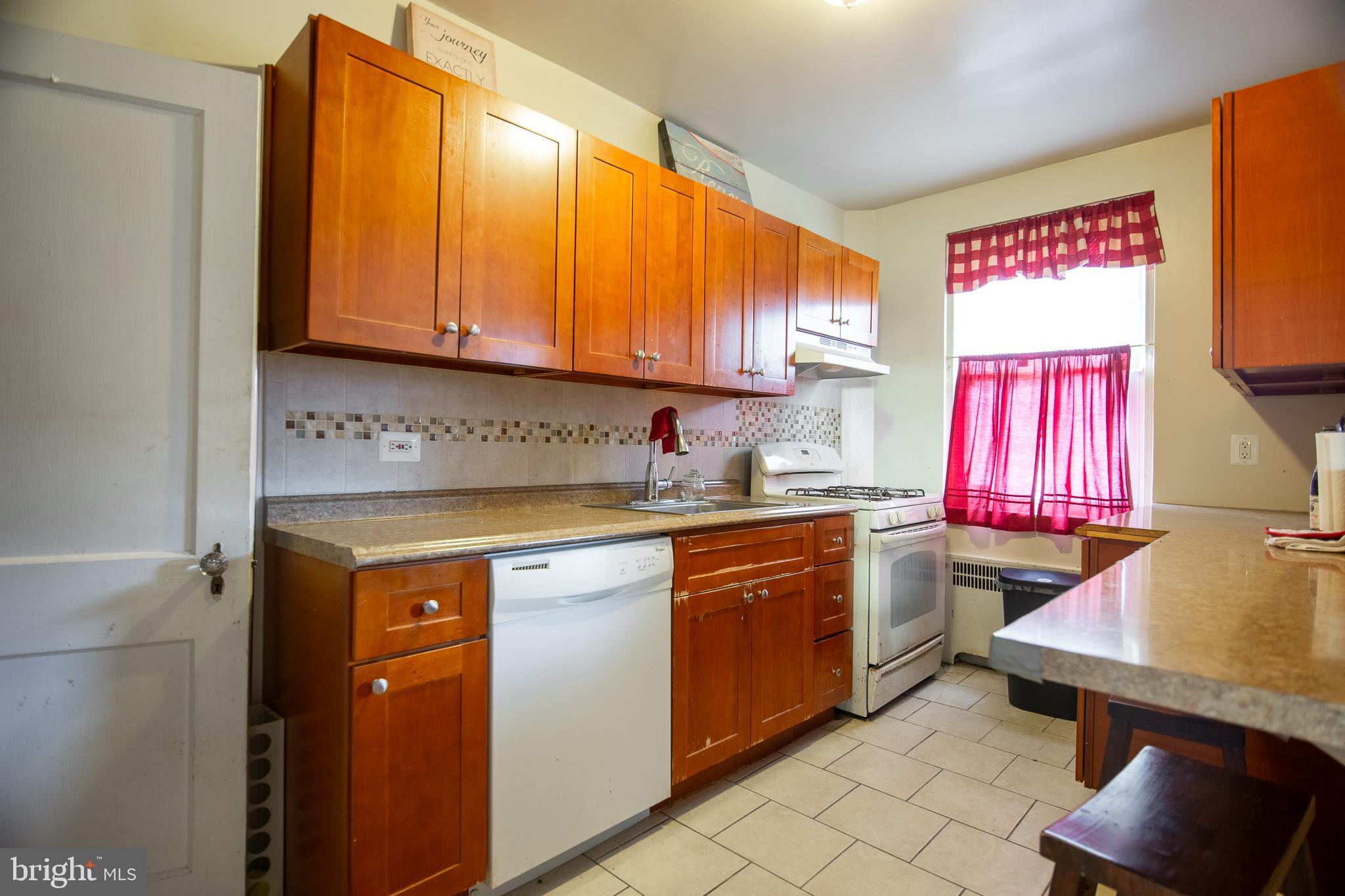 7617 Woolston Avenue Philadelphia, PA 19150 - Photo 8 of 24 a kitchen with a sink cabinets and window