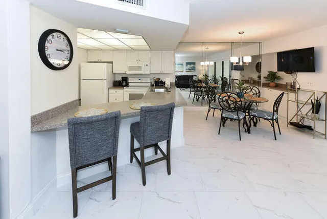 a large white kitchen with a table and chairs