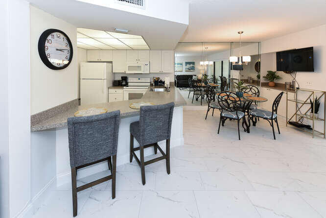 1605 Highway 1, Unit B105 Jupiter, FL 33477 - Photo 12 of 30 a large white kitchen with a table and chairs