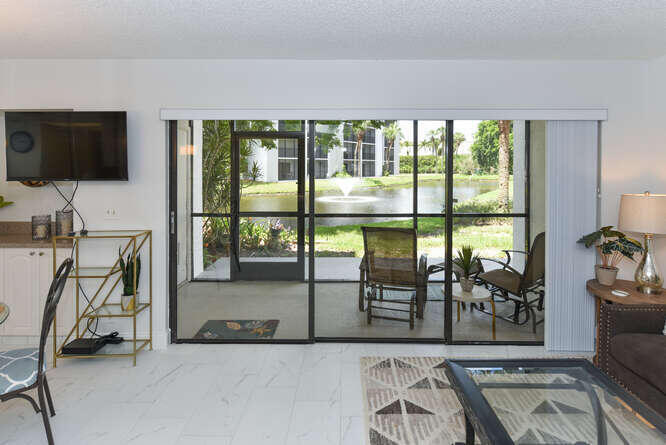 1605 Highway 1, Unit B105 Jupiter, FL 33477 - Photo 15 of 30 a view of a livingroom with furniture wooden floor and a flat screen tv