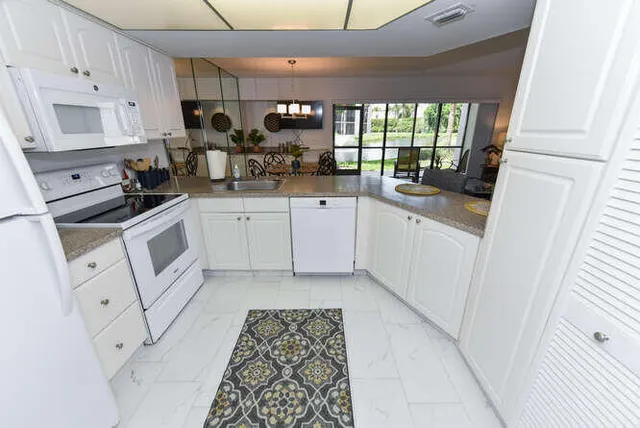 a kitchen with white cabinets and white appliances