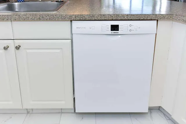 a close view of a granite countertop white cabinet and a granite counter top
