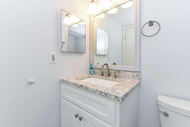 1605 Highway 1, Unit B105 Jupiter, FL 33477 - Photo 8 of 30 a bathroom with a granite countertop sink and a mirror