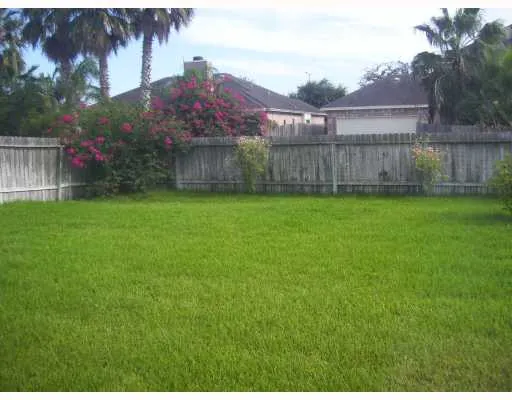 a view of a backyard with a garden and wooden fence