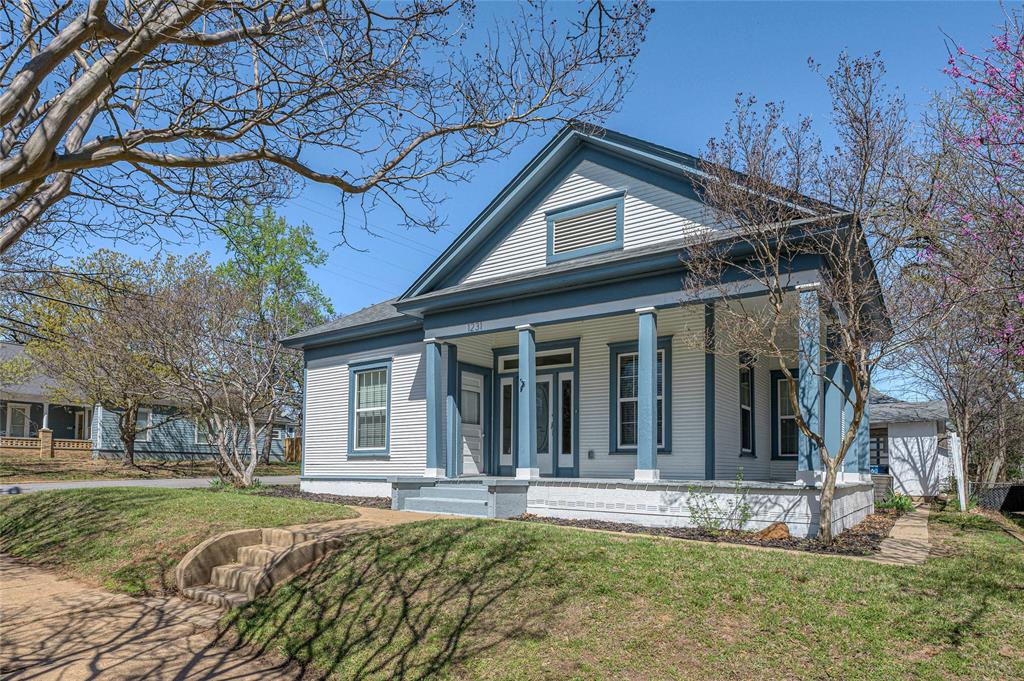1231 West Main Street Denison, TX 75020 - Photo 6 of 31 a view of a house with a large tree and a yard in front of it