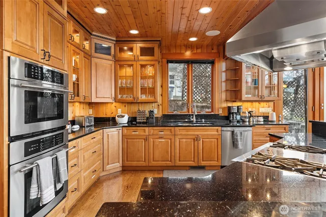 a kitchen with stainless steel appliances granite countertop a stove sink and cabinets