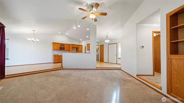 a view of an empty room with a ceiling fan and window