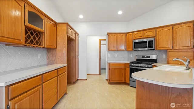 a kitchen with stainless steel appliances granite countertop a stove a sink and a refrigerator