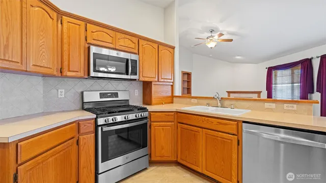 a kitchen with stainless steel appliances granite countertop a stove and a microwave