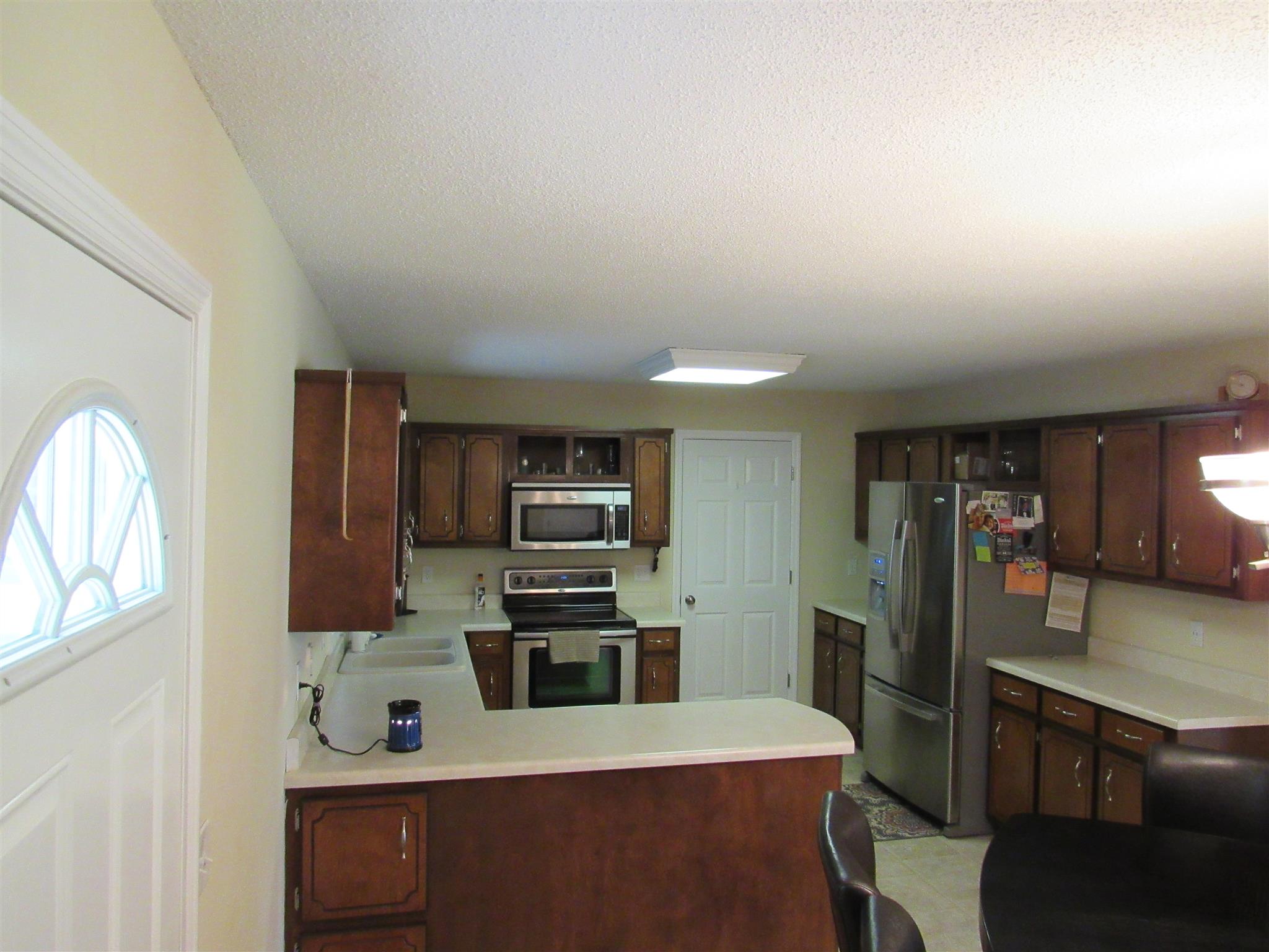 1070 Riley Creek Road Tullahoma, TN 37388 - Photo 6 of 17 a kitchen with stainless steel appliances kitchen island granite countertop a refrigerator a stove and a sink with wooden floor