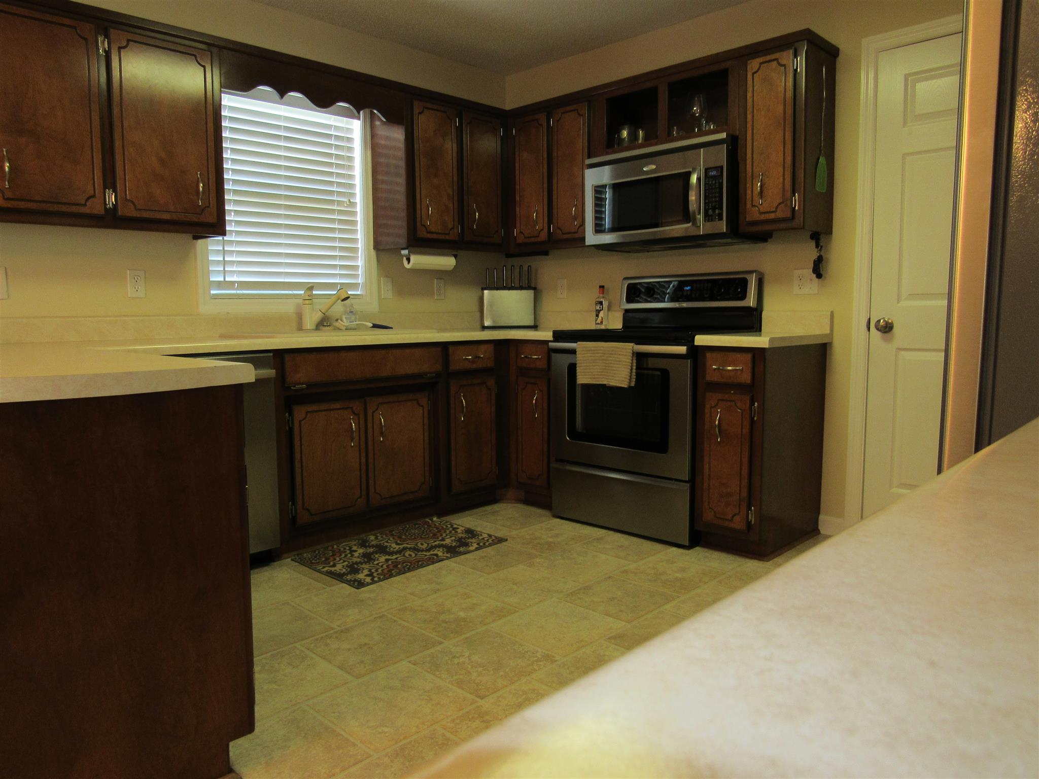 1070 Riley Creek Road Tullahoma, TN 37388 - Photo 7 of 17 a kitchen with stainless steel appliances granite countertop wooden cabinets a stove top oven a sink and dishwasher