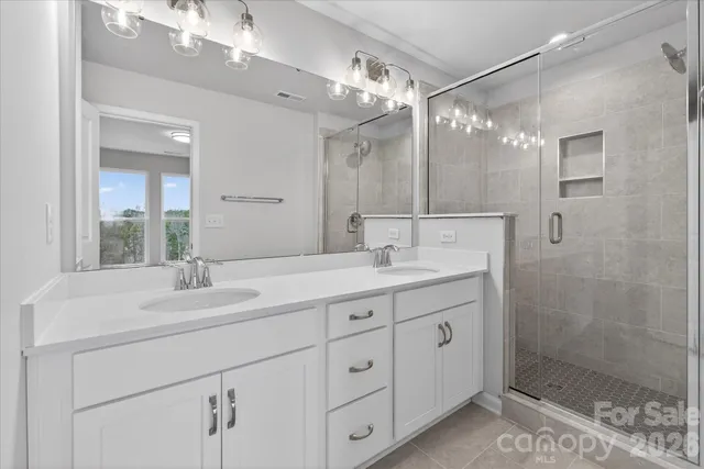 a bathroom with a granite countertop sink mirror and shower