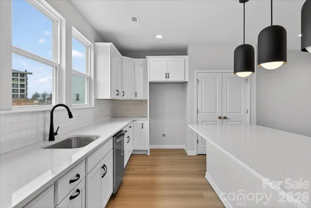 a kitchen with white cabinets a sink and dishwasher