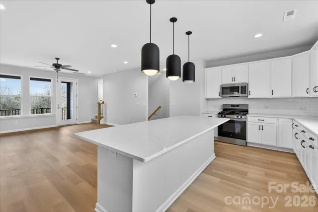 a view of a kitchen with wooden floor and a sink