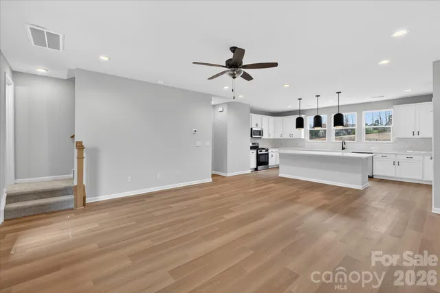a view of room with wooden floor and fan