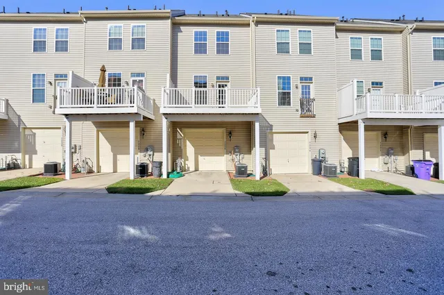 a front view of a house with yard and parking