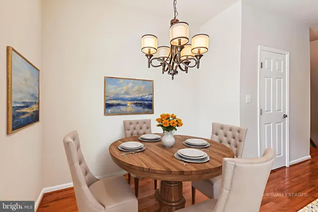 a view of a dining room with furniture a chandelier and wooden floor