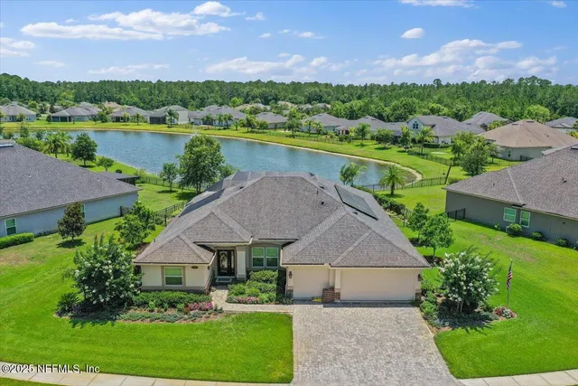 an aerial view of a house with a garden and lake view