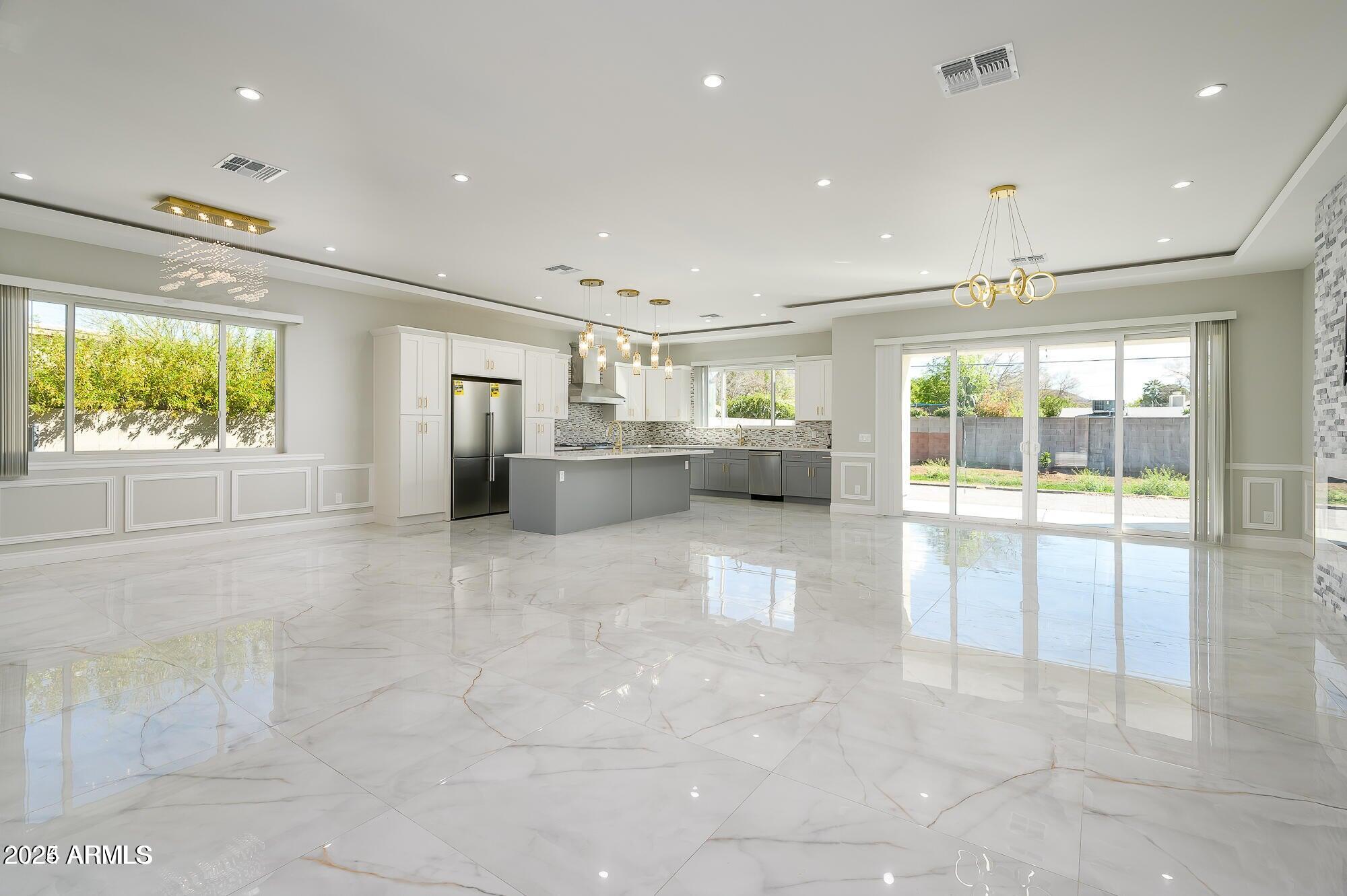 a open kitchen with stainless steel appliances granite countertop a refrigerator and a sink