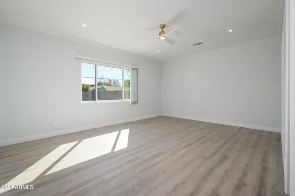 an empty room with wooden floor and windows
