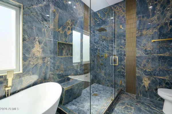 a bathroom with a granite countertop sink a toilet and shower