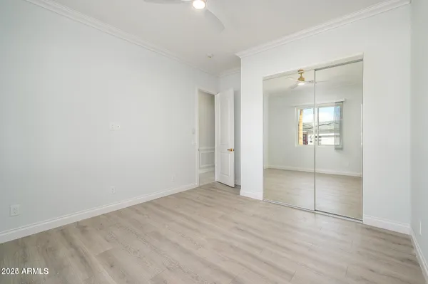 an empty room with mirror and a bathroom