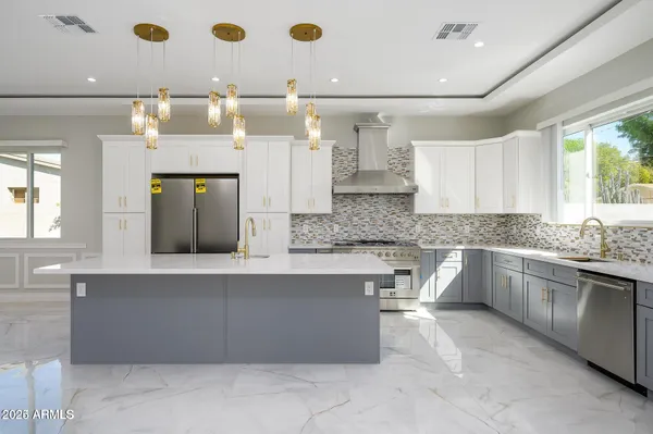 a large kitchen with kitchen island a sink stainless steel appliances and cabinets