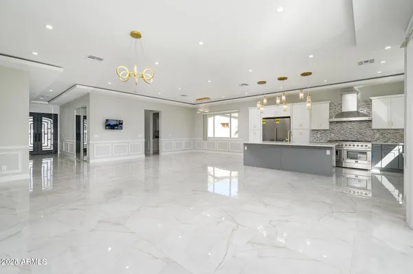 a view of a kitchen with kitchen island stainless steel appliances refrigerator stove microwave and cabinets