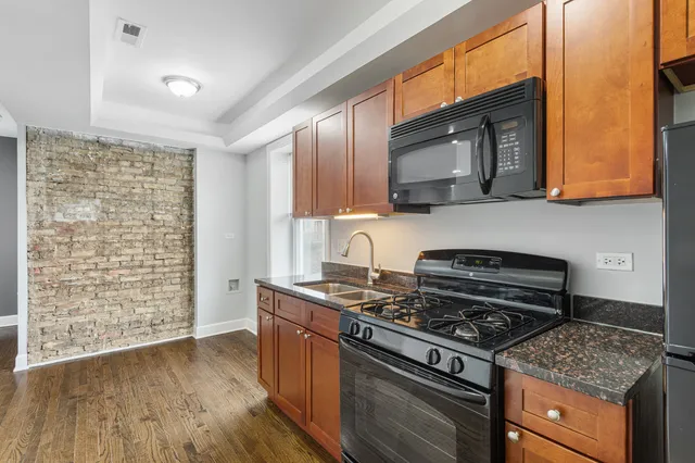 a kitchen with granite countertop a stove and a wooden cabinets