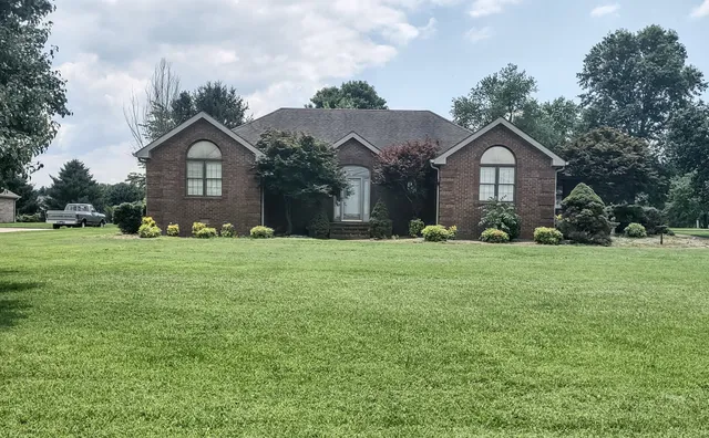 a front view of a house with yard and green space