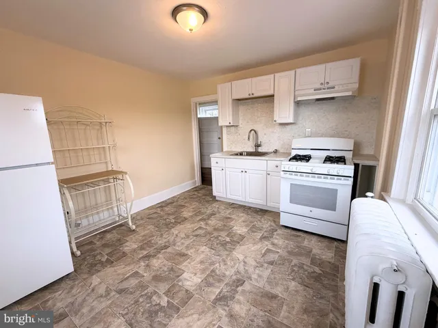 a kitchen with a stove top oven and cabinets